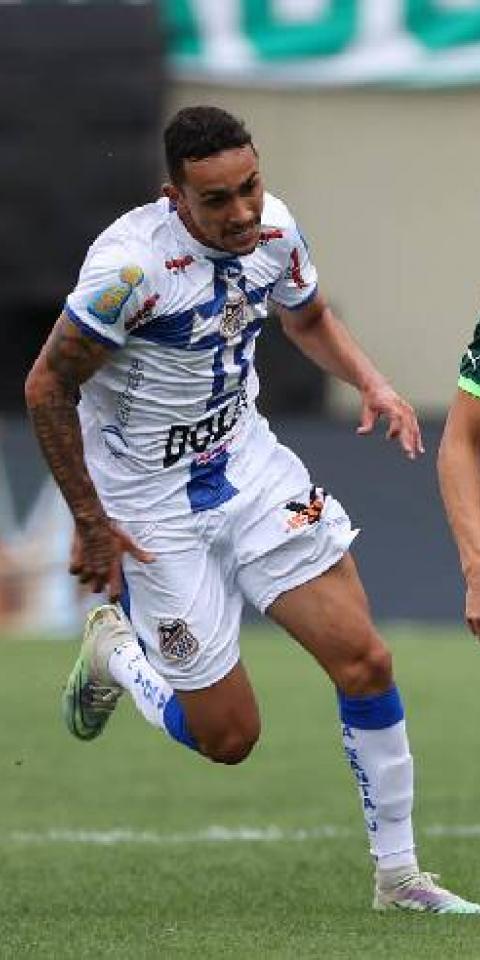 O jogador Raphael Veiga, da SE Palmeiras, disputa bola com o jogador do EC Água Santa, durante partida válida pela final, ida, do Campeonato Paulista, Série A1, na Arena Barueri.